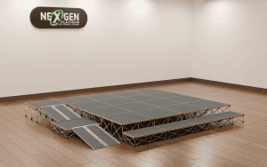 Modular gray-stage platforms with ramps arranged in a studio, a NextGen Platinum sign on the wall above.