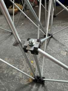 NexGen Riser Leg Link Clamp (Single) 6 Pack This spare parts connects riser legs together of different heights, for use with differing height riser legs where the deck platforms cannot be aligned. Such as a lower step or tier setup. Place the link clamp around the taller of the two riser legs, and over the Close-up of a metal scaffold joint with a bolt and clamp on a concrete floor coasted by cross braces and rails, mid-assembly piece.