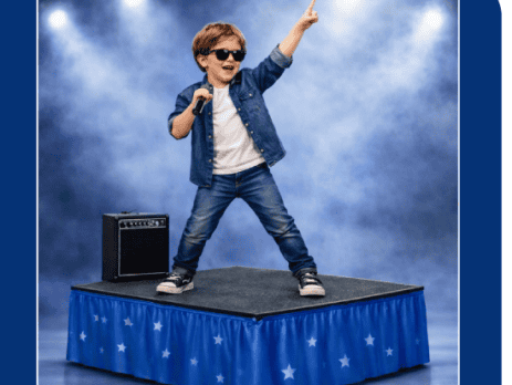 Buying a stage for a school is rarely as simple as finding a price online. A primary school may need a compact platform for assemblies and performances. A secondary school may need a larger modular system for concerts, awards evenings, drama productions and community events. That means school stage cost in the UK can vary from Young boy performing on a stage with a microphone, wearing sunglasses and a denim jacket, raising one arm in the spotlight.